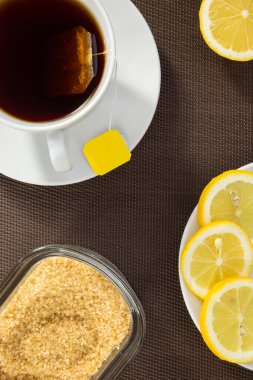 çay bardağı, dilim limon ve kahverengi şeker
