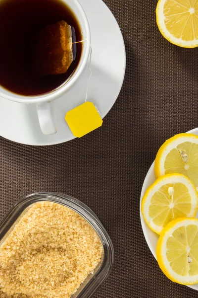 Tasse à thé, tranches de citron et sucre brun — Photo