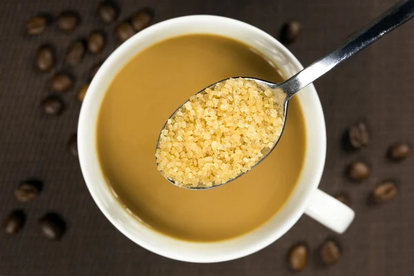 Brązowy cukier na łyżkę i filiżankę kawy — Zdjęcie stockowe