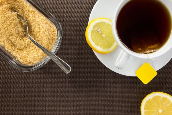 Tea cup, brown sugar and slice of lemon — Stock Photo, Image