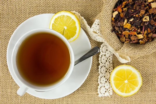 Taza caliente de té y hojas secas de hierbas — Foto de Stock