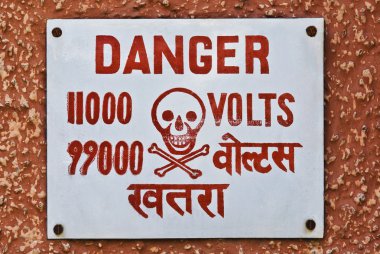 yüksek gerilim uyarı tabela bir duvar