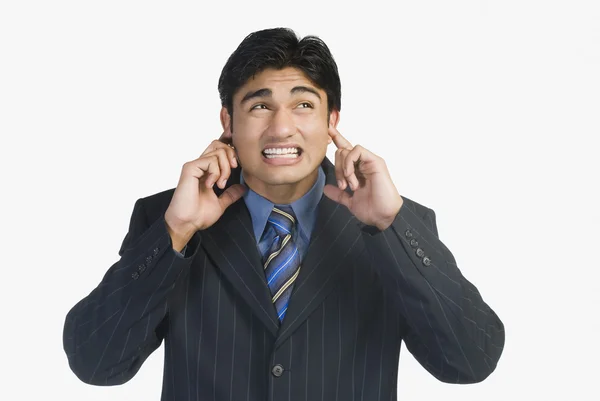 Businessman with his fingers in ears — Stock Photo, Image