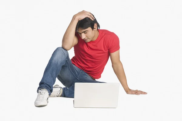 Homem sentado na frente de um laptop — Fotografia de Stock