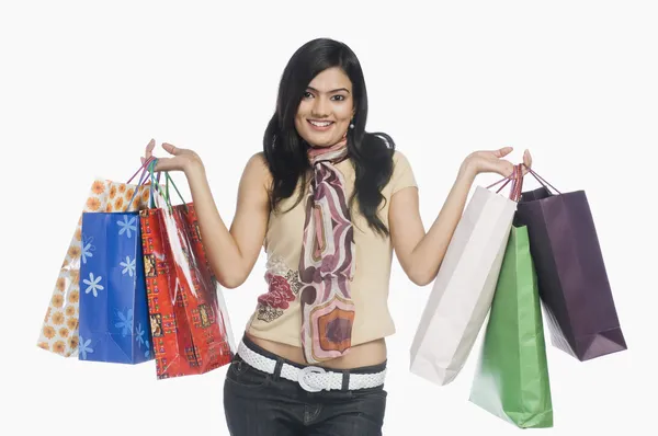 Mujer llevando bolsas de compras y sonriendo — Foto de Stock