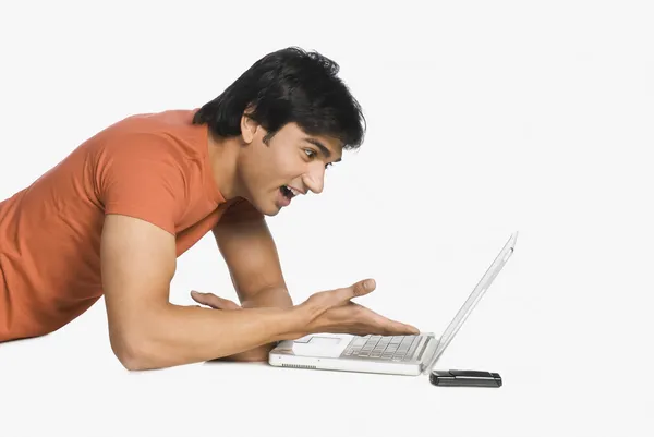 Homem trabalhando em um laptop e surpreso — Fotografia de Stock