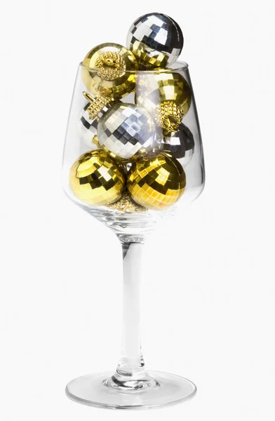 Gold and silver baubles in a wine glass — Stock Photo, Image