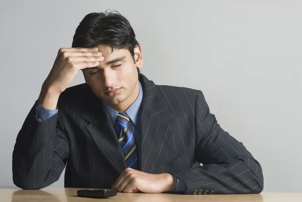 Businessman rubbing his forehead — Stock Photo, Image