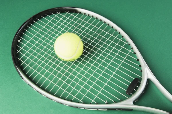 Raquete de tênis com uma bola de tênis — Fotografia de Stock