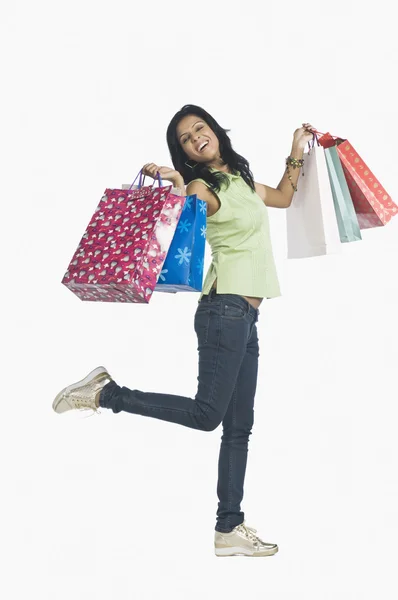 Vrouw uitvoering boodschappentassen en glimlachen — Stockfoto