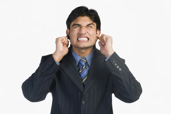 Businessman with his fingers in ears — Stock Photo, Image