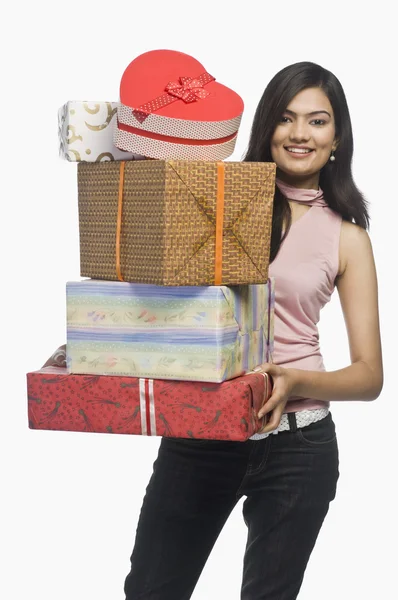 Woman holding gift boxes and smiling — Stock Photo, Image