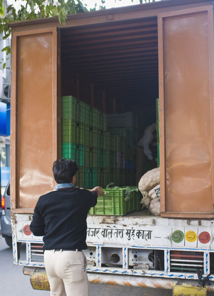 Men unloading vegetables in a truck