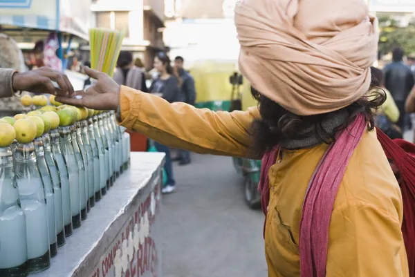 Street vendor giving alms to a beggar — Stock Photo, Image