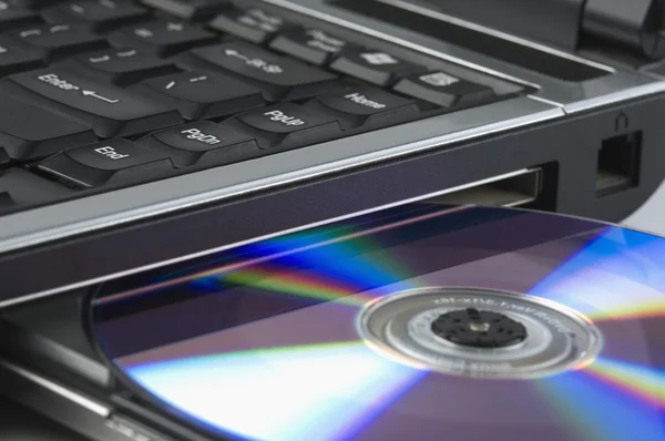 Laptop mata ut en cd — Stockfoto