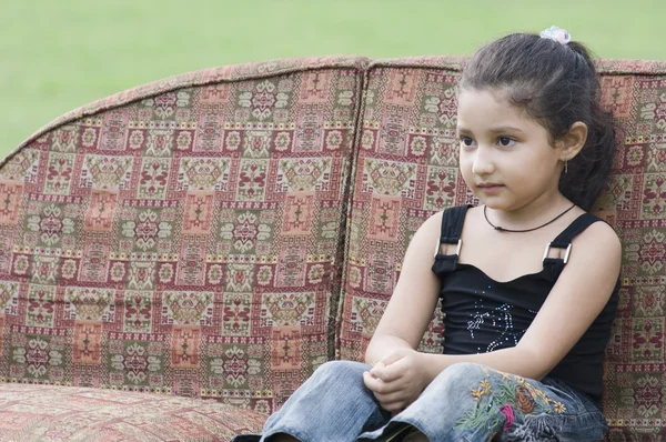 Dziewczyna siedząca na kanapie — Zdjęcie stockowe