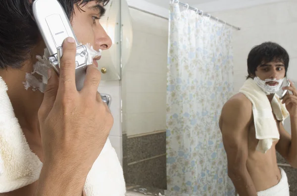 Man praten op een mobiele telefoon in de badkamer — Stockfoto