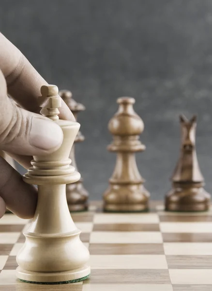 Human hand moving a king chess piece — Stock Photo, Image