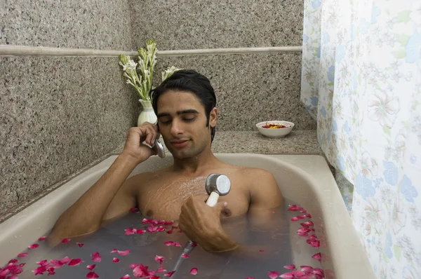 Man die een douche nemen en praten op een mobiele telefoon — Stockfoto