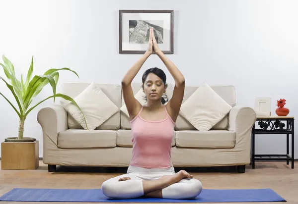 Woman meditating in a living room — Stock Photo, Image