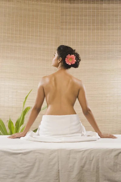 Vrouw zitten op een massagetafel — Stockfoto