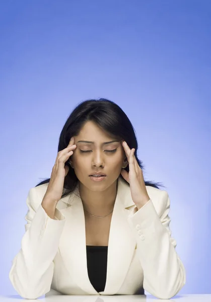 Businesswoman rubbing her temple — Stock Photo, Image