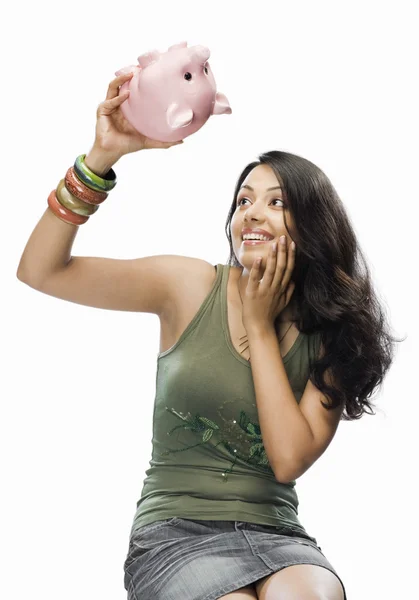 Woman picking up a piggy bank — Stock Photo, Image