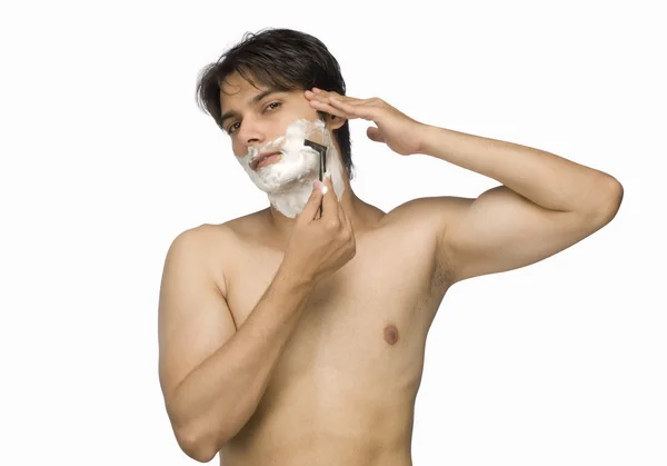 Мужчина бреет лицо — стоковое фото