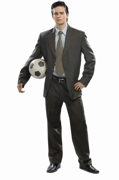 Obchodník držící fotbalový míček — Stock fotografie