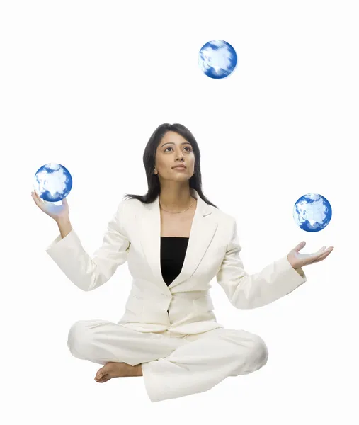 Businesswoman juggling globes — Stock Photo, Image