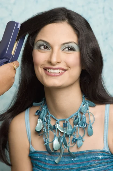 Engomar o cabelo de uma jovem — Fotografia de Stock