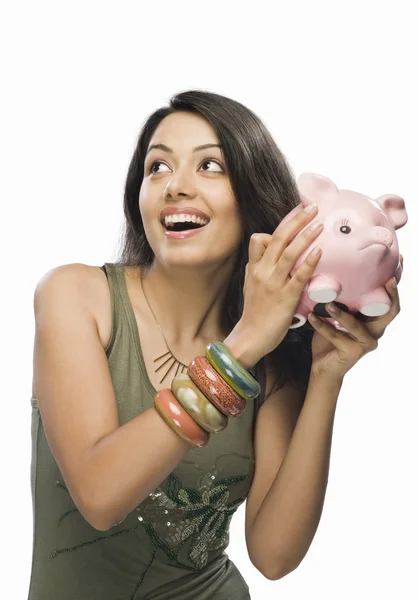 Woman shaking a piggy bank — Stock Photo, Image