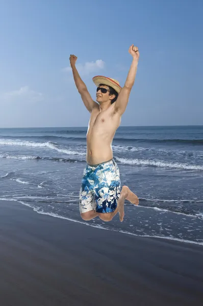 Man springt op het strand — Stockfoto