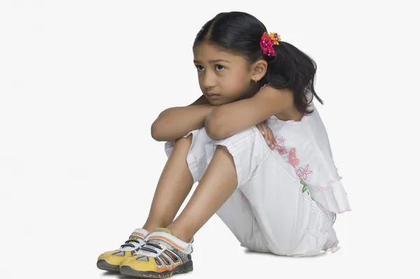 Girl resting her face on her knees — Stock Photo, Image