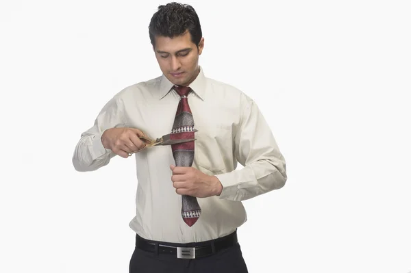 Empresário cortando sua gravata por tesoura — Fotografia de Stock