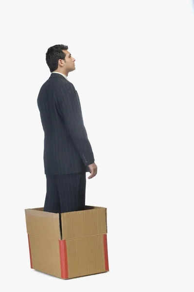 Businessman standing in a cardboard box — Stock Photo, Image