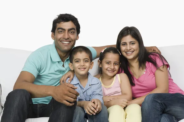 Familia feliz sentada en un sofá — Foto de Stock