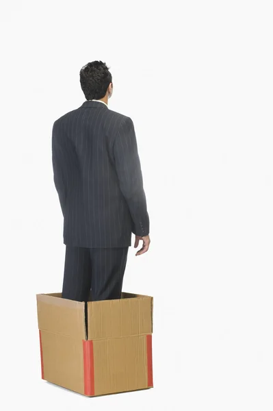 Businessman standing inside a cardboard box — Stock Photo, Image