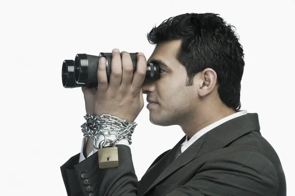 Businessman looking through binoculars — Stock Photo, Image