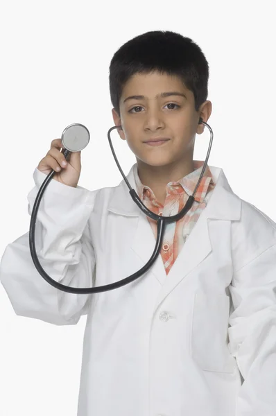Önlük giymiş ve elinde stetoskop bir çocuk — Stok fotoğraf
