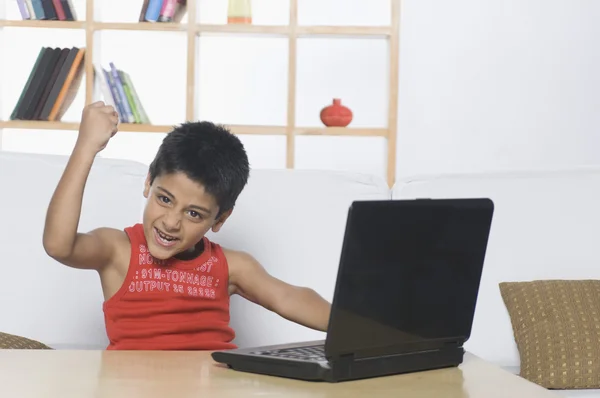 Jongen die op een laptop werkt — Stockfoto