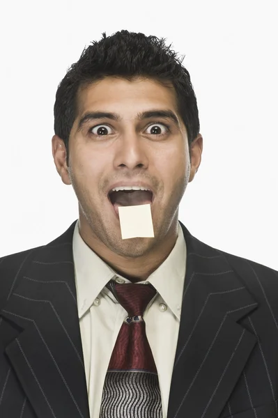 Businessman with an adhesive note on his lips — Stock Photo, Image