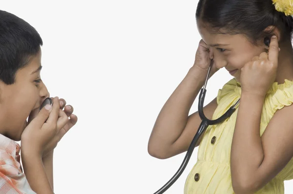 Boy speaking into stethoscope and a girl listening — Stock Photo, Image