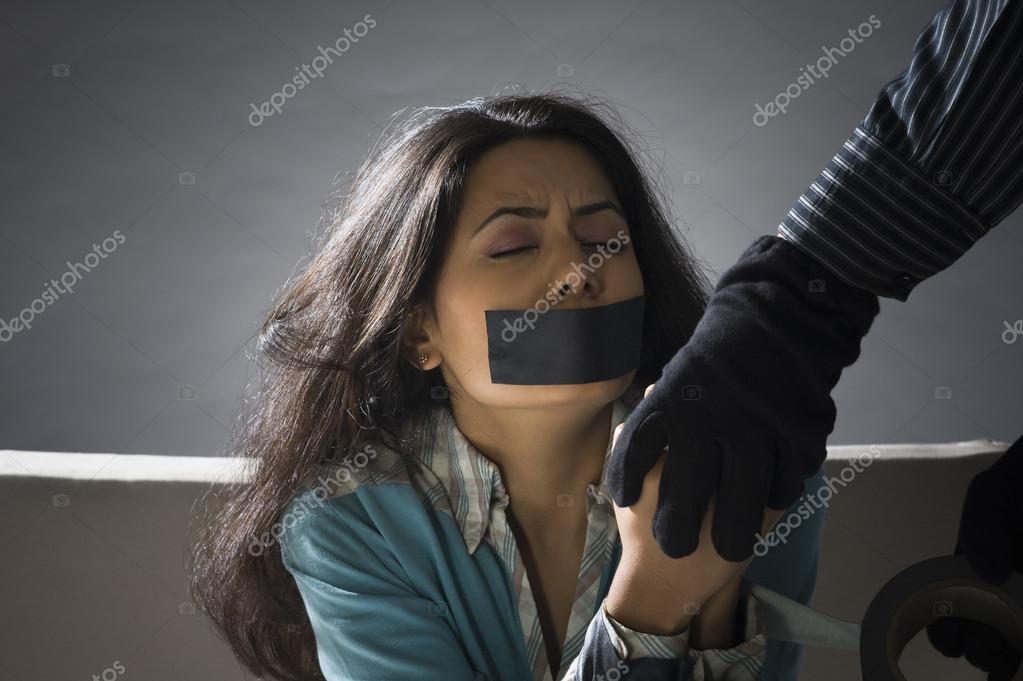 Hands wrapping adhesive tape around woman's hands Stock Photo by