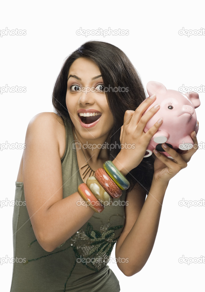 Woman shaking a piggy bank
