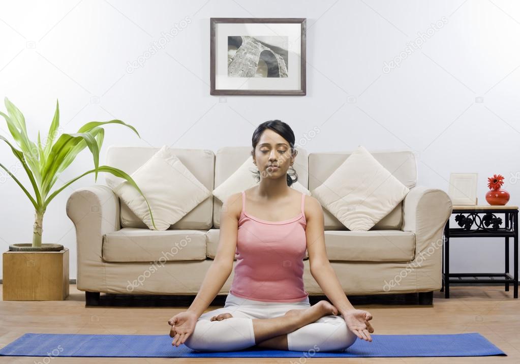 Woman meditating in a living room