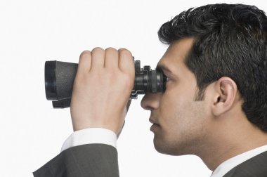 Dürbünle bakan bir iş adamı