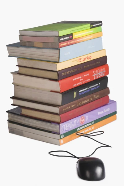 Stapel boeken en een computermuis — Stockfoto