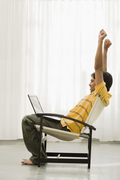ノート パソコンと肘掛け椅子に坐っていた男 — ストック写真