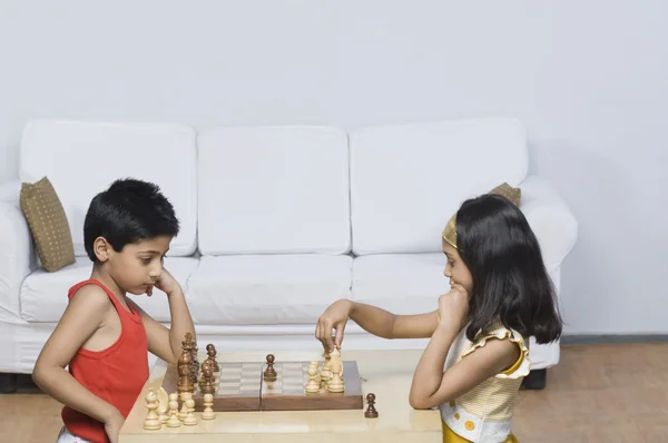 Garçon et une fille jouant aux échecs — Photo